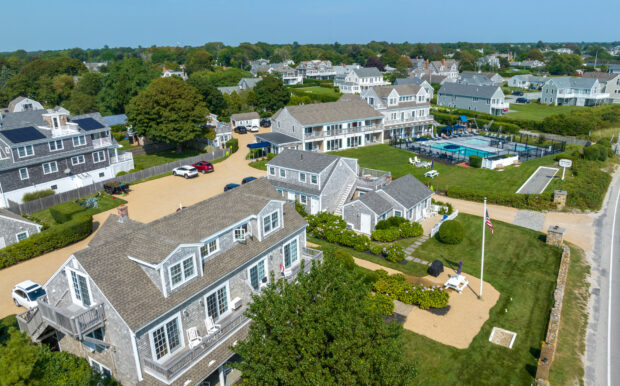 View of Beachside Village Resort’s cottages, lush green lawns, pool area, and nearby oceanfront.